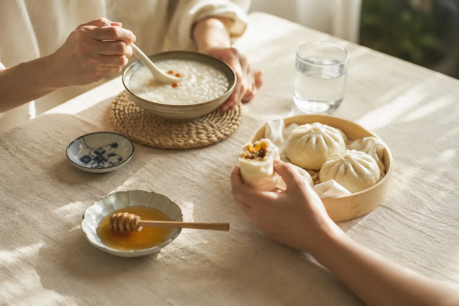清晨的家庭餐桌，粥、包子与一碟蜂蜜